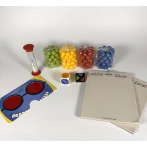 May include: A Cranium board game set with various components. Includes a red and white hourglass, a blue and yellow card with red circles, dice, and pads of paper. There are also bags of green, yellow, red, and blue spheres.