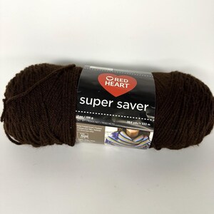Könnte beinhalten: Ein Knäuel dunkelbraune Red Heart Super Saver Wolle. Das Etikett zeigt den Markennamen, das Gewicht von 198 g und die Länge von 333 m. Das Garn ist fest gewickelt und bereit für Strick- oder Häkelprojekte.