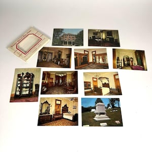 May include: A collection of vintage postcards featuring interior and exterior views of a historic home. The postcards showcase rooms with antique furniture and architectural details. A small box with text is also included.