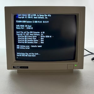 May include: A beige TRAC VGA colour monitor displaying a black screen with white text showing BIOS information, including Award Modular BIOS v4.51PG, CPU details, memory test results, and a CMOS checksum error message indicating a battery failure.