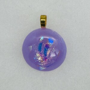 May include: A round, purple glass pendant with iridescent flecks and a gold bail.