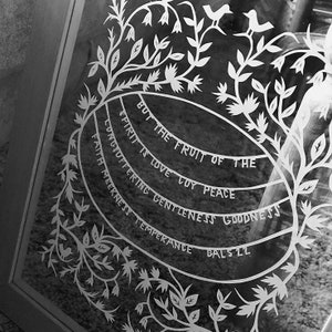 May include: Black and white image of a decorative wall hanging with a floral design and the text "But the fruit of the spirit is love, joy, peace, longsuffering, gentleness, goodness, faith, meekness, temperance".