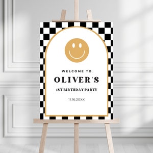 May include: A black and white checkered welcome sign with a gold smiley face and the text "Welcome to Oliver's 1st Birthday Party 11.16.20XX".