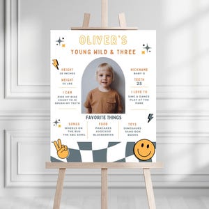 May include: A white and yellow printable poster with a photo of a child, a checkered pattern, and the text "Oliver's Young Wild & Three". The poster includes information about the child's height, weight, nickname, teeth, favorite things, and activities.