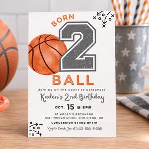 May include: A rectangular birthday invitation card featuring a basketball theme with the text BORN 2 BALL, Kaden's 2nd Birthday, Oct. 15 at 2pm, Kaden's Backyard, 123 Harbor Drive, San Diego, CA, Concession Stand Open, and RSVP to Coach Jen at 533-655-6655.