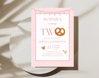 May include: A pink birthday invitation with the text "Sophia is turning TWO". The invitation includes a pretzel graphic, a heart-shaped cookie, and a banner. The invitation is for Sophia's 2nd birthday.