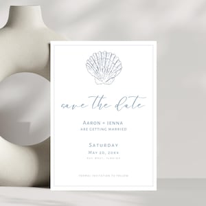 K&ouml;nnte beinhalten: Eine wei&szlig;e Save-the-Date-Karte mit einer blauen Muschel-Illustration. Der Text lautet "save the date", "Aaron + Jenna are getting married", "Saturday, May 20, 20XX", und "Formal invitation to follow".