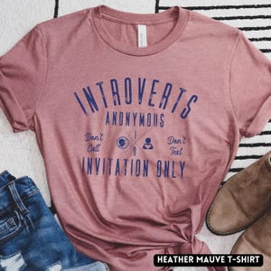 May include: A white ceramic mug with a black handle and the text "But First, Coffee" in a black, bold font. The mug is on a white surface.