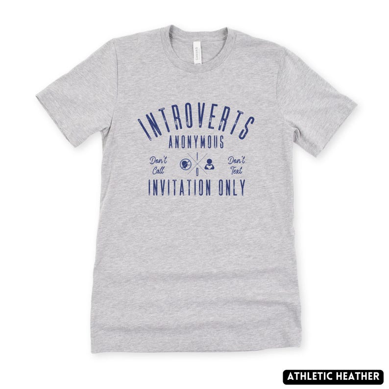 May include: A grey athletic heather t-shirt with the blue text "Introverts Anonymous". The shirt also has the phrases "Don't Call, Don't Text, Invitation Only" in blue. The t-shirt is a crew neck style.