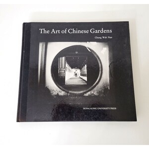 May include: A hardcover book titled "The Art of Chinese Gardens" by Chung Wah Nan. The cover features a black and white photograph of a circular architectural element framing a long corridor with a person walking in the distance. The publisher is Hong Kong University Press.