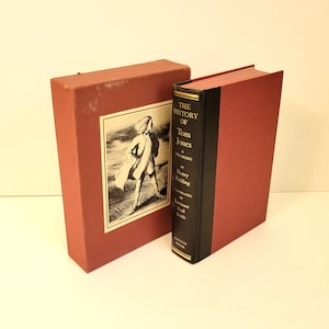 May include: A hardcover book titled "The History of Tom Jones, A Foundling" by Henry Fielding, with a red cover and black spine. The book is in a matching red box with a black and white illustration of a man.