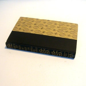 May include: A black and gold hardcover book titled "Selected Tales of Guy de Maupassant". The book cover features a repeating pattern of stylized leaves.