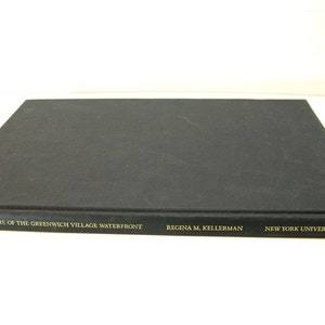 May include: Black hardcover book with gold lettering on the spine. The title is "The Architecture of the Greenwich Village Waterfront" by Regina M. Kellerman. The book is published by New York University Press.