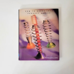 May include: A book titled "How to Break Into Product Design" with a colorful cover featuring three abstract, spring-like objects. The objects have metallic bases and spiral coils, with orange, red, and green accents. The author's name, Pamela Williams, is also visible.