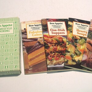 May include: A set of four Bon Appétit Homestyle Cooking softcover books titled Fabulous Cakes, One-Dish Suppers, Hearty Soups, and Classic Breads, accompanied by a light green patterned storage box with the same series title printed on the front.