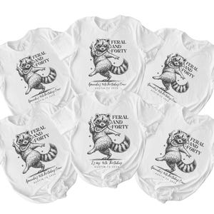 Puede incluir: Camisetas blancas con un dise&ntilde;o de mapache y el texto "FERAL AND FORTY". El mapache lleva un collar de perlas y gafas de sol. El texto "Amanda's 40th Birthday Crew, Austin, TX 2024" tambi&eacute;n est&aacute; impreso.