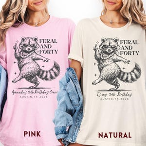Puede incluir: Dos camisetas, una rosa y otra natural, con un gr&aacute;fico de mapache con gafas de sol y un collar de perlas. El texto en las camisetas dice "FERAL AND FORTY". La camiseta rosa dice "Amanda's 40th Birthday Crew, Austin, TX 2026". La camiseta natural dice "It's my 40th Birthday, Austin, TX 2026".