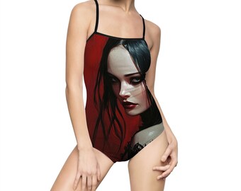 May include: A black one-piece swimsuit with a red and black illustration of a woman's face. The woman has long black hair and dark eyes.