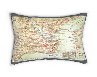 May include: Rectangular pillow featuring a vintage map design with a gray border. The map is in shades of beige, red, and green, with detailed geographical features and text. The pillow is a decorative home accent.
