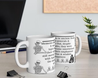 May include: White ceramic coffee mug with a black and white illustration of a skeleton sitting with the text "Memento Mori" and a quote about ancient Roman generals.