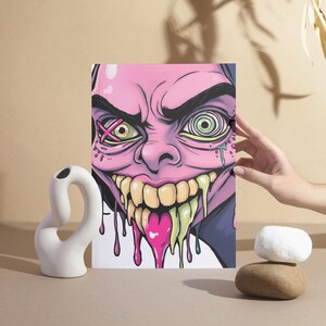 May include: A pink and green cartoon face with a wide open mouth and dripping slime. The face has a cross over one eye and a spiral in the other eye.