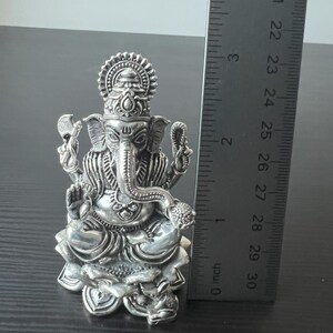 Op de afbeelding: Zilveren Ganesha-beeldje dat op een lotusbasis zit. Het beeldje is ongeveer 7,5 cm hoog.