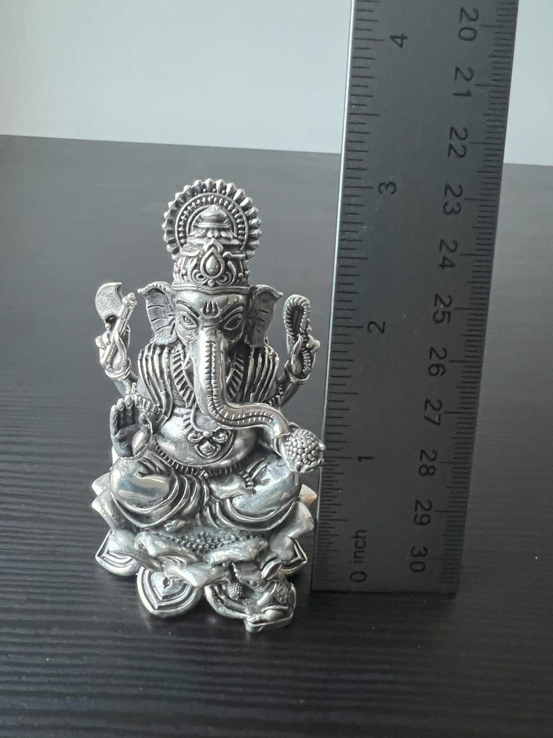 Op de afbeelding: Zilveren Ganesha-beeldje dat op een lotusbasis zit. Het beeldje is ongeveer 7,5 cm hoog.