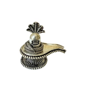 Könnte beinhalten: Eine silberfarbene religiöse Skulptur mit einem Lingam, einer Kobrahaube und einer Basis mit aufwendigen Details. Die Skulptur hat eine glatte, polierte Oberfläche und ist vor einem weißen Hintergrund platziert.