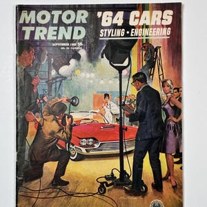 May include: Vintage Motor Trend magazine cover from September 1963 featuring a red convertible car and a photoshoot scene. The cover has the text "MOTOR TREND '64 CARS STYLING ENGINEERING". The magazine cover has a retro aesthetic.