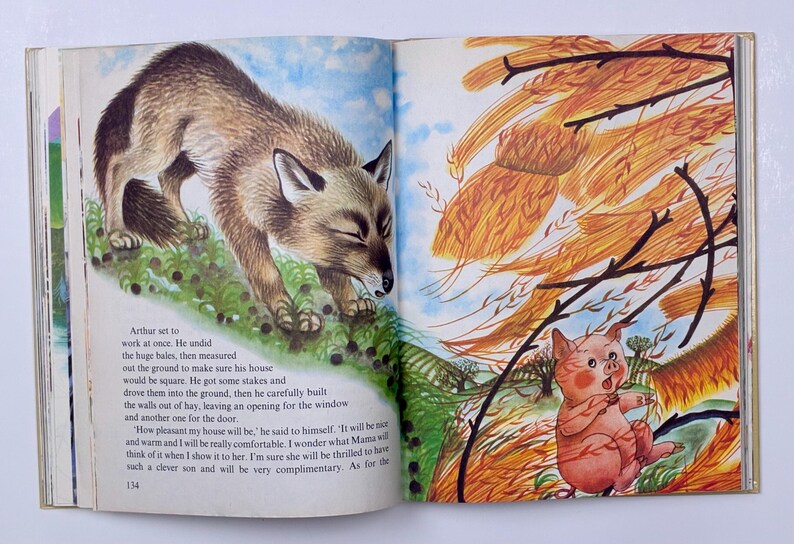 Może przedstawiać: Ilustracja z otwartej książki przedstawiająca lisa i świnię. Lis jest brązowy i brązowy, na zielonej trawie. Świnia jest r&oacute;żowa, patrząc na wiązkę siana. Tekst jest widoczny na lewej stronie.