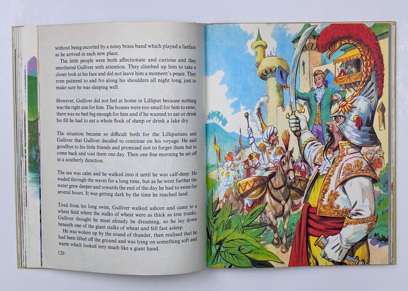 Może przedstawiać: Kolorowa ilustracja z książki dla dzieci. Mężczyzna w zbroi podnosi miecz, w tle tłum i konie. Scena rozgrywa się przed zamkiem, z wieloma szczeg&oacute;łami.