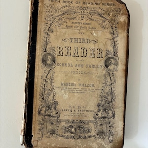 May include: An antique book titled "The Third Reader" from the "School and Family Series." The cover is aged with visible wear and tear, featuring ornate floral designs and portraits. The text includes the author's name, publisher, and the series title.