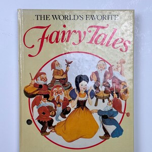 Może przedstawiać: Książka w stylu vintage zatytułowana "The World's Favorite Fairy Tales". Okładka przedstawia ilustrację Kr&oacute;lewny Śnieżki i Siedmiu Krasnoludk&oacute;w w okrągłym wzorze. Tytuł jest w czerwonej, kursywnej czcionce.