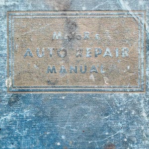 May include: An antique auto repair manual with a distressed blue cover. The title "Major's Auto Repair Manual" is printed in faded lettering within a rectangular frame on the cover. The book shows signs of wear and age.