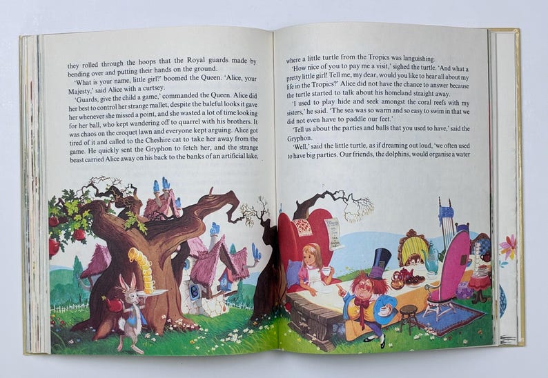 Może przedstawiać: Otwarta książka z kolorowymi ilustracjami z bajki dla dzieci. Jedna strona przedstawia kr&oacute;lika serwującego herbatę, druga przyjęcie herbaciane z Alicją. Widoczny jest tekst.