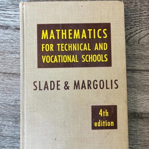 May include: A vintage textbook titled "Mathematics for Technical and Vocational Schools" by Slade & Margolis. The cover is a light beige with dark brown and yellow text. The 4th edition is noted in a small square.