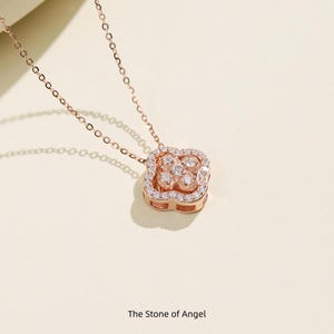 May include: Rose gold necklace with a square pendant featuring a four-leaf clover design. The pendant is encrusted with small, sparkling clear stones. The chain is delicate. The text "The Stone of Angel" is at the bottom.