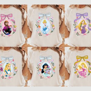 a woman wearing a white shirt with princesses on it
