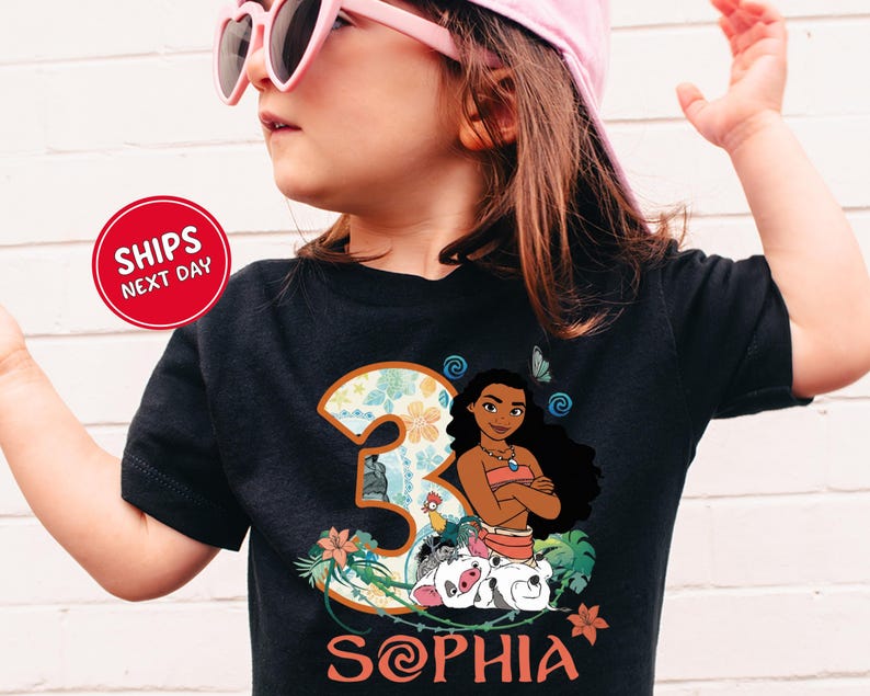 A young girl wearing a black t-shirt with a graphic of a character from the movie "Mulan" and the number 3, along with the text "Sophia".