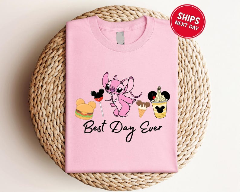 A pink t-shirt with a cartoon character and various Disney-themed items, such as a Mickey Mouse, a hamburger, and a milkshake, along with the text "Best Day Ever".