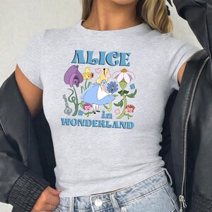 A gray t-shirt with a graphic design featuring a character from the "Alice in Wonderland" series.