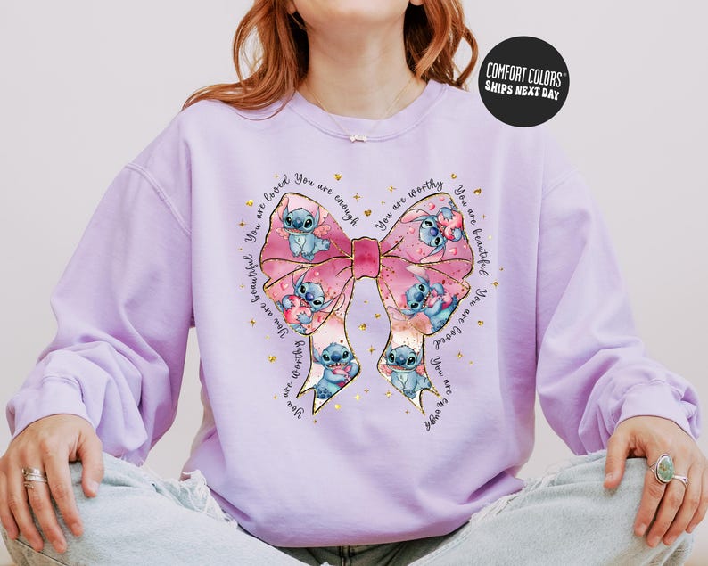 A person wearing a purple sweater with a large bow and various cartoon characters printed on it.