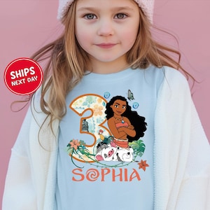 A young girl wearing a t-shirt with a cartoon image of a girl and the number 3, along with the text "Sophia".