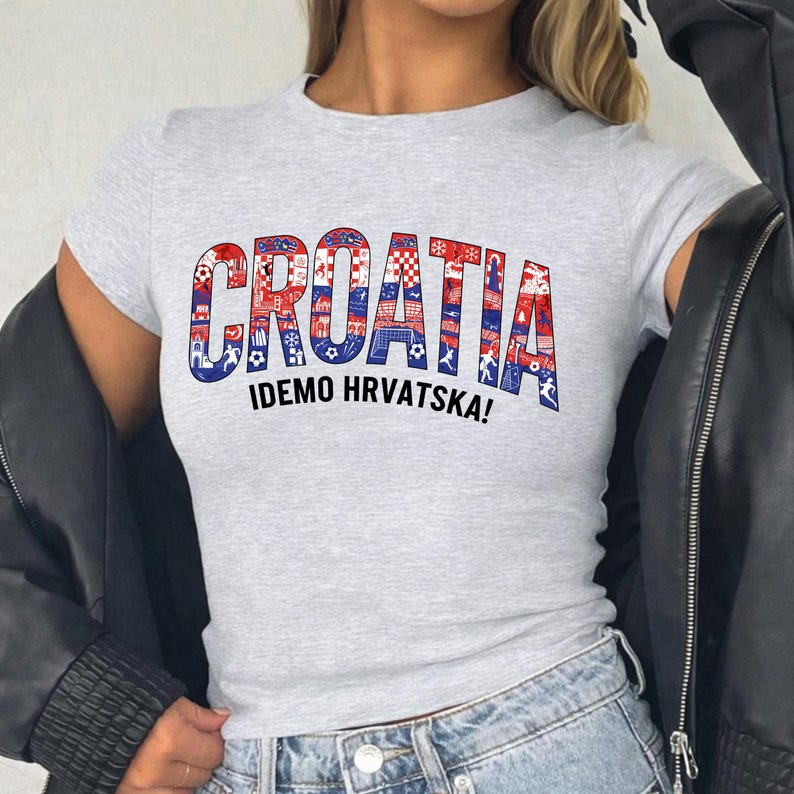 A person wearing a grey t-shirt with the word "Croatia" printed on it, along with the phrase "IDEMO HRVATSKA!" printed below.