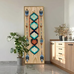 May include: A tall, rectangular wooden wall art piece featuring a vertical arrangement of geometric diamond shapes in shades of turquoise, blue, and brown, flanked by stylized arrow motifs on a light-colored wood grain background with a thin gold frame.