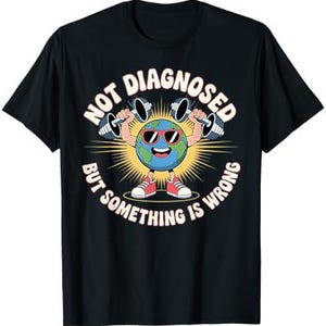 Op de afbeelding: Zwart t-shirt met een afbeelding van de aarde met een zonnebril en gewichten. De tekst luidt "NOT DIAGNOSED BUT SOMETHING IS WRONG" in een cirkel rond de aarde.