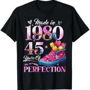 May include: Black t-shirt with a pink and white floral design. The text "Made in 1980 45 Years of Perfection" is printed on the shirt.