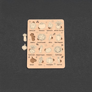 Op de afbeelding: Houten groentepuzzel met 16 verschillende groenten, waaronder sla, tomaat en wortel. Elke groente is voorzien van zijn naam. Inclusief aparte puzzelstukjes voor selderij en ui.