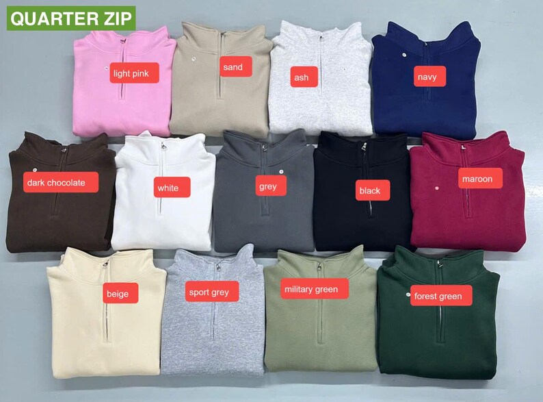 May include: A collection of quarter-zip sweatshirts in various colors, including light pink, sand, ash, navy, dark chocolate, maroon, white, grey, black, beige, sport grey, military green, and forest green. Each sweatshirt has a zipper closure.
