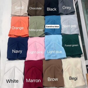 May include: A collection of hoodies in various colors, including sand, chocolate, black, grey, orange, milita green, carolina blue, sport grey, navy, light pink, light blue, forest green, white, marron, brow, and begi. The word "HOODIE" is at the top.